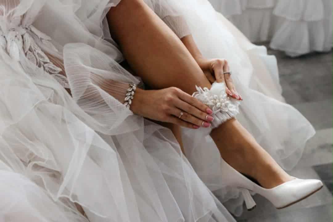 Biała podwiązka ślubna z aplikacją z koronki i perłami