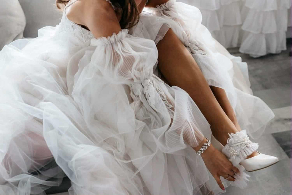 Biała podwiązka ślubna z aplikacją z koronki i perłami