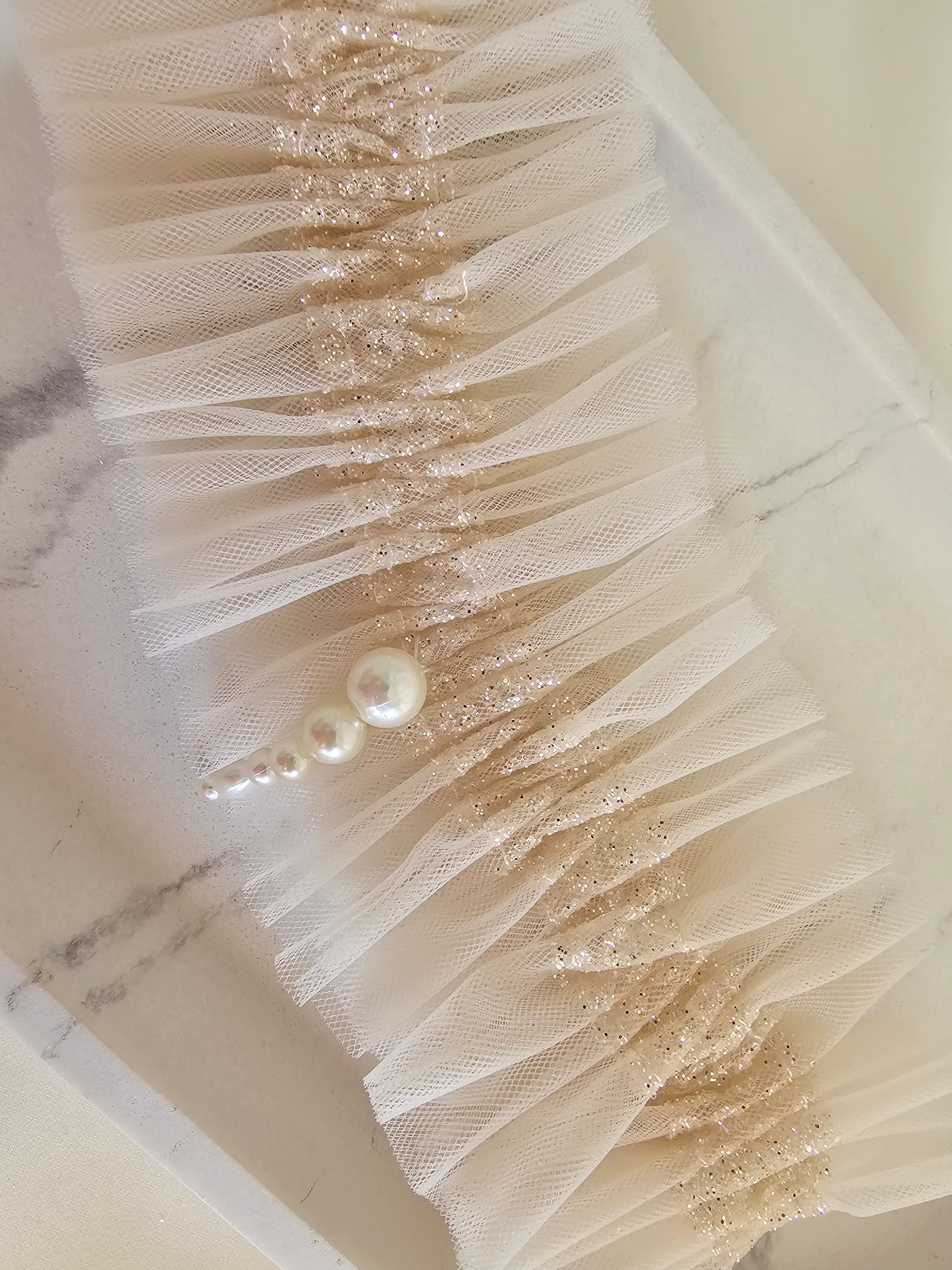 Podwiązka z najnowszej kolekcji Pearls z tiulu w kolorze kości słoniowej z dodatkiem złotego włoskiego tiulu oraz pereł.