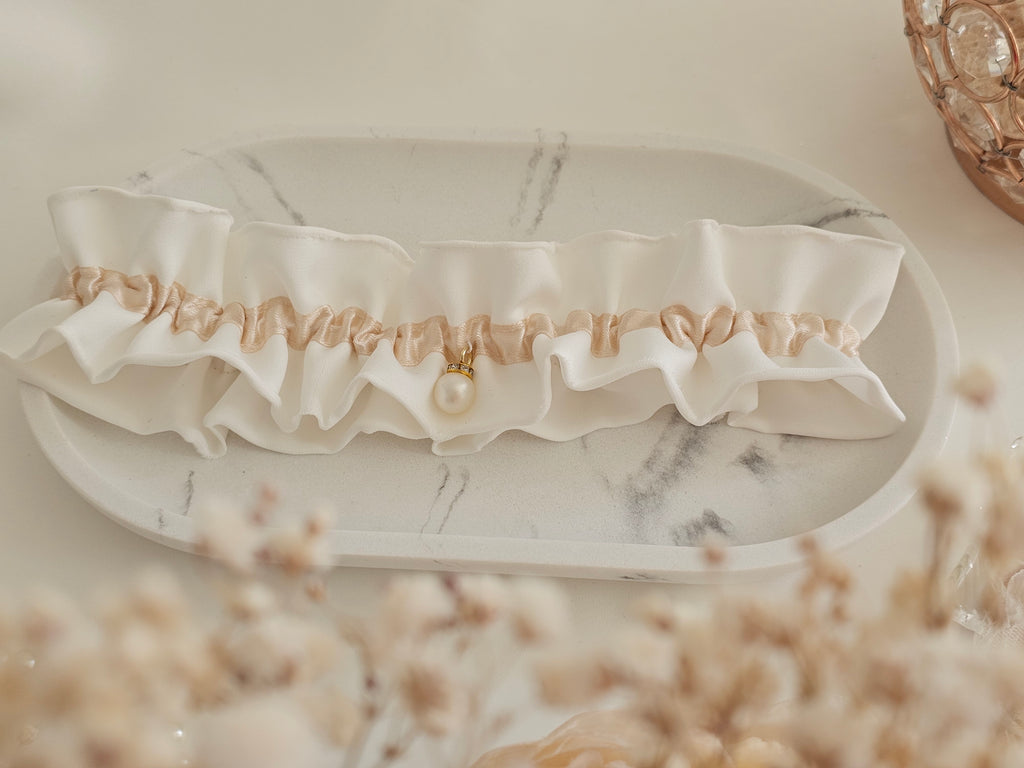 Podwiązka ślubna z kolekcji PEARLS z satyny z dodatkiem szampańskiej wstążki i perły