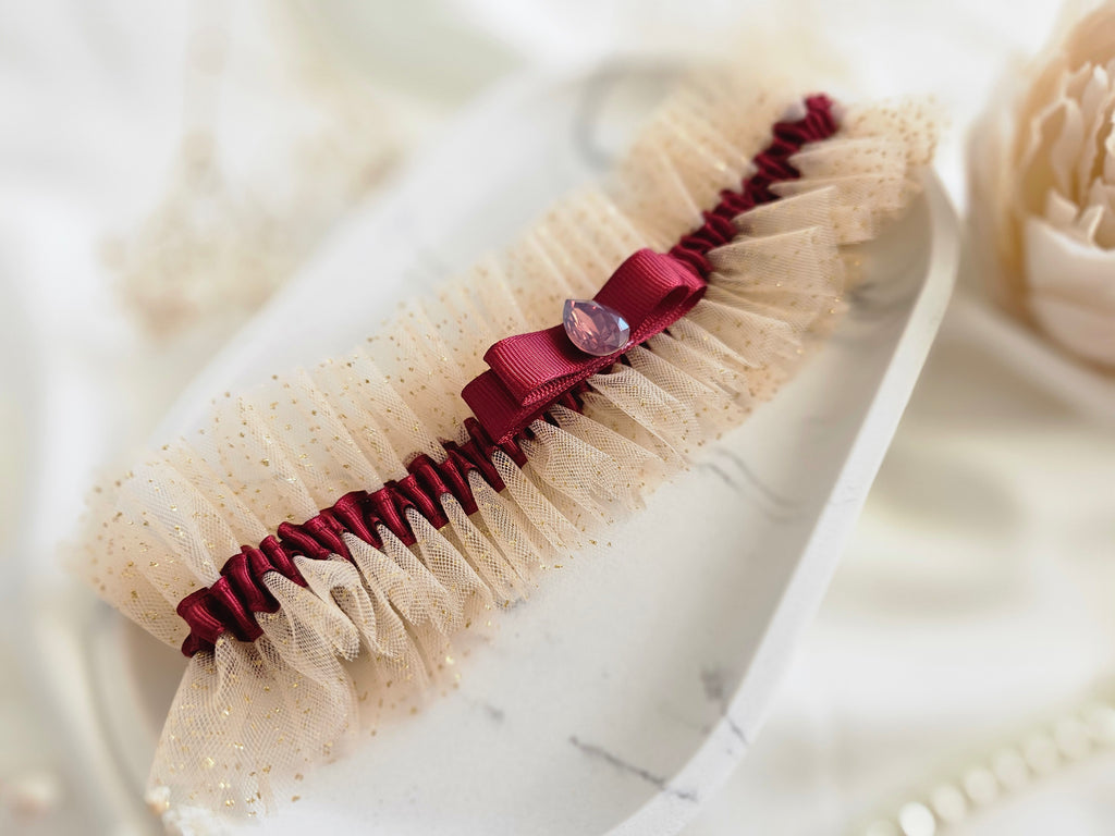 Podwiązka ślubna że złotego tiulu z bordową wstążką i kamyczkiem