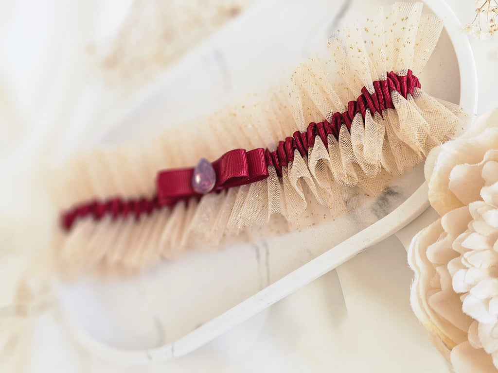 Podwiązka ślubna że złotego tiulu z bordową wstążką i kamyczkiem