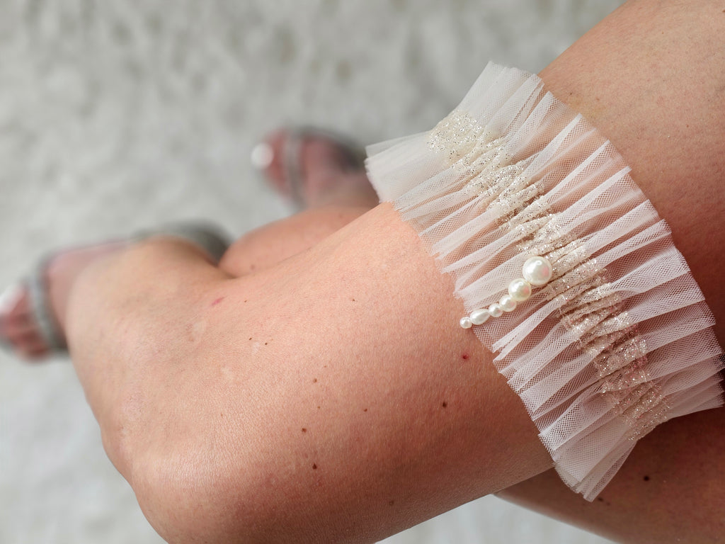 Podwiązka z najnowszej kolekcji Pearls z tiulu w kolorze kości słoniowej z dodatkiem złotego włoskiego tiulu oraz pereł.