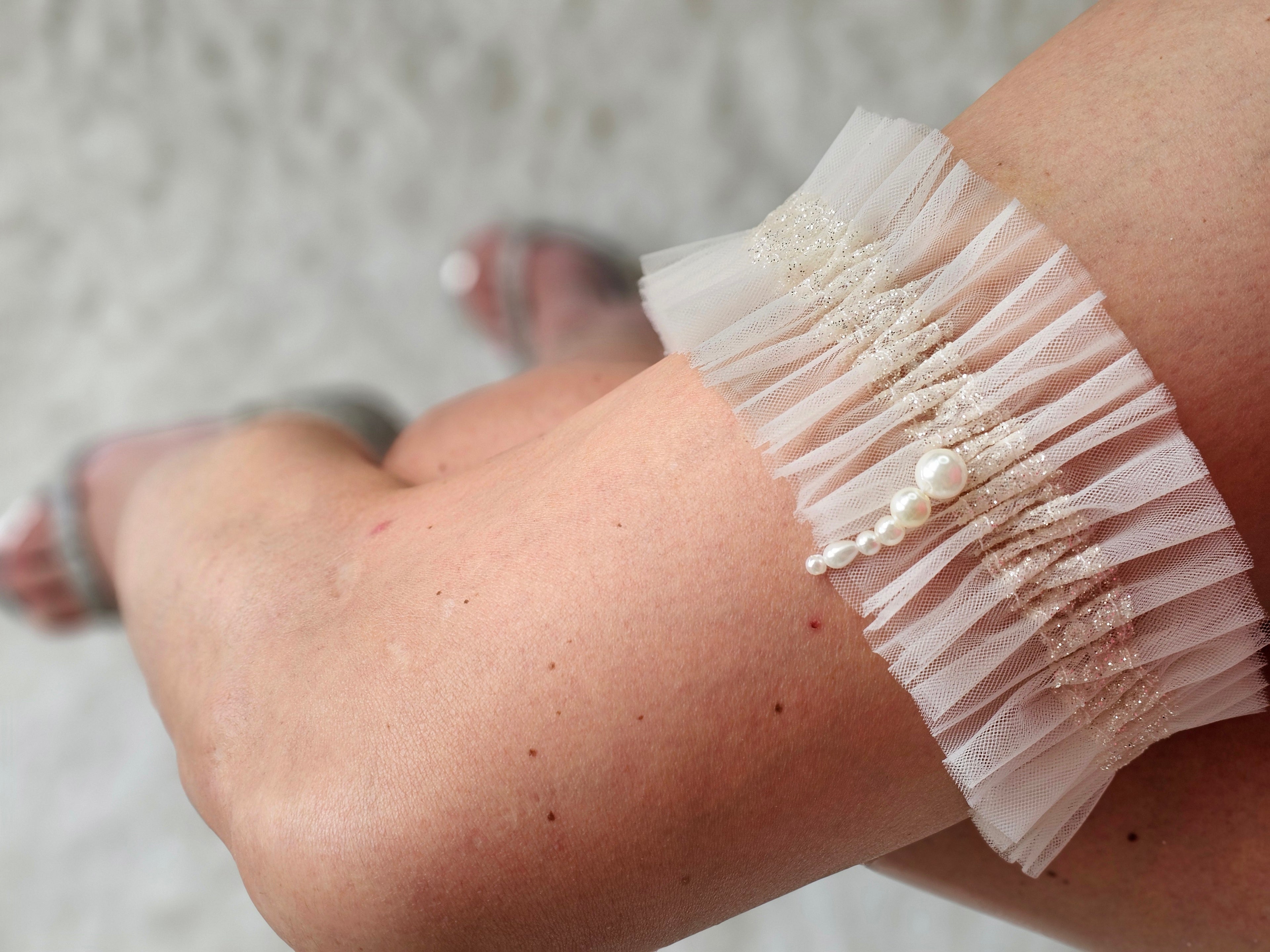 Podwiązka z najnowszej kolekcji Pearls z tiulu w kolorze kości słoniowej z dodatkiem złotego włoskiego tiulu oraz pereł.