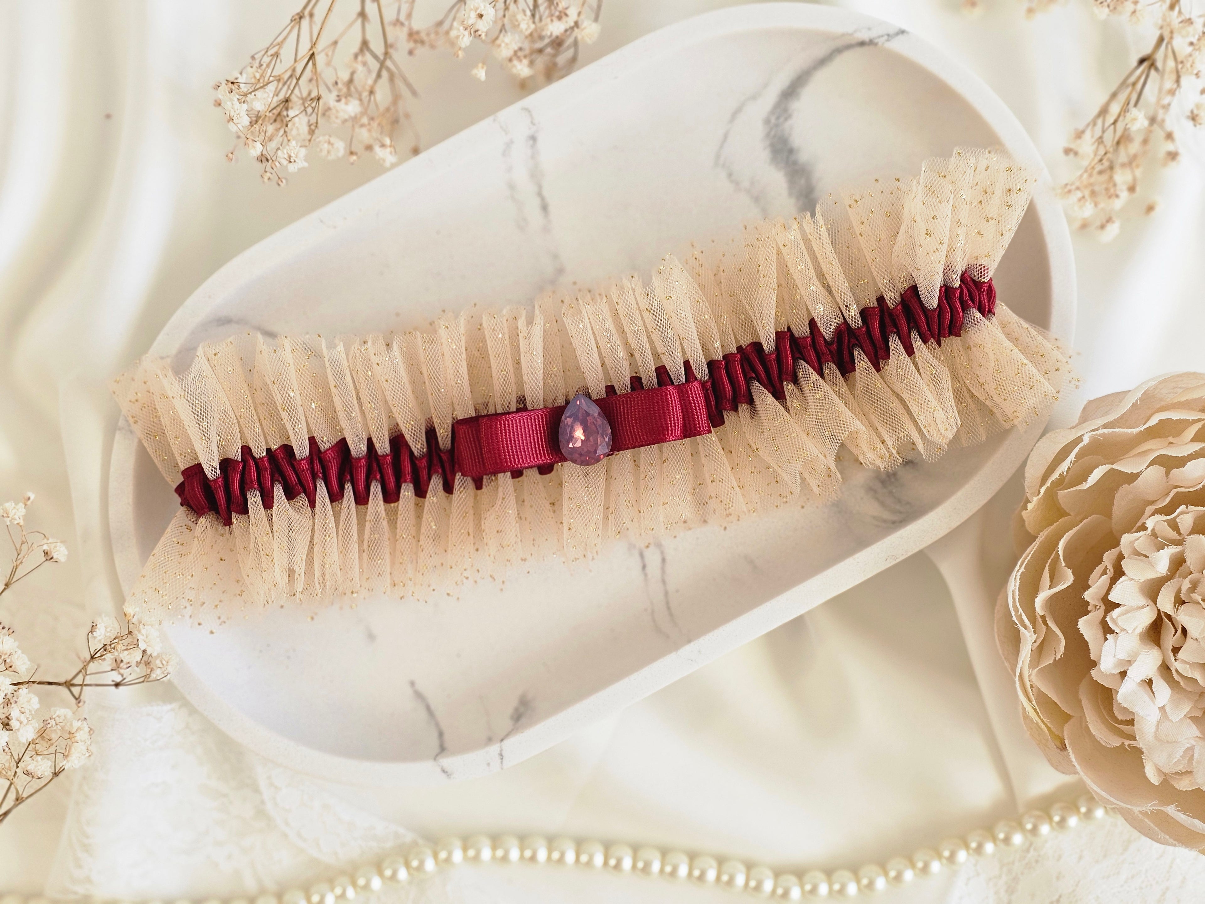 Podwiązka ślubna że złotego tiulu z bordową wstążką i kamyczkiem