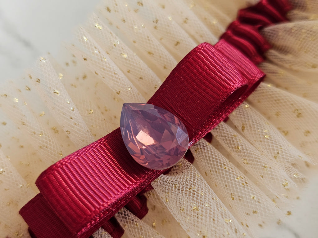 Podwiązka ślubna że złotego tiulu z bordową wstążką i kamyczkiem